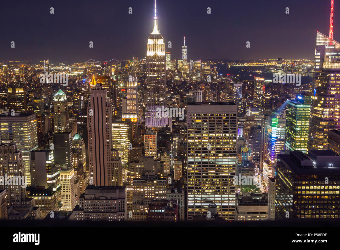 La Ciudad de Nueva York en la noche, visto desde la cima de la roca. El Empire State Building en el centro del bastidor, torre de la libertad en la distancia. Foto de stock