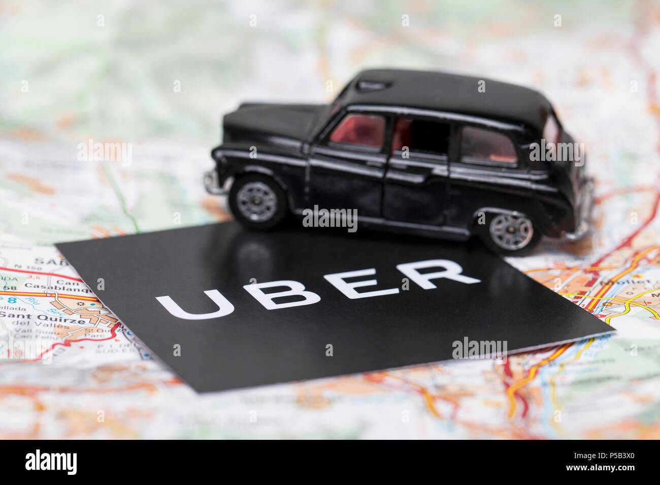 Londres, Reino Unido - 23 de marzo de 2017: Una fotografía de la Uber logotipo con un negro estilo londinense taxi coche de juguete. Uber es un popular servicio de transporte taxi estilo app Foto de stock