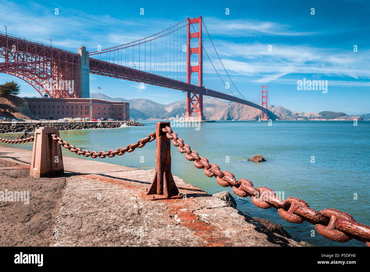 Vista clásica del famoso puente Golden Gate con punto de Fort National Historic Site en un hermoso día soleado con el cielo azul y las nubes, San Francisco, EE.UU. Foto de stock