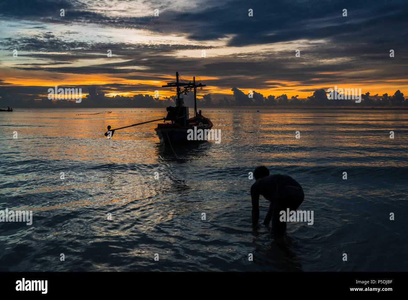 Pescador prepararse para trabajar en el alba. Foto de stock