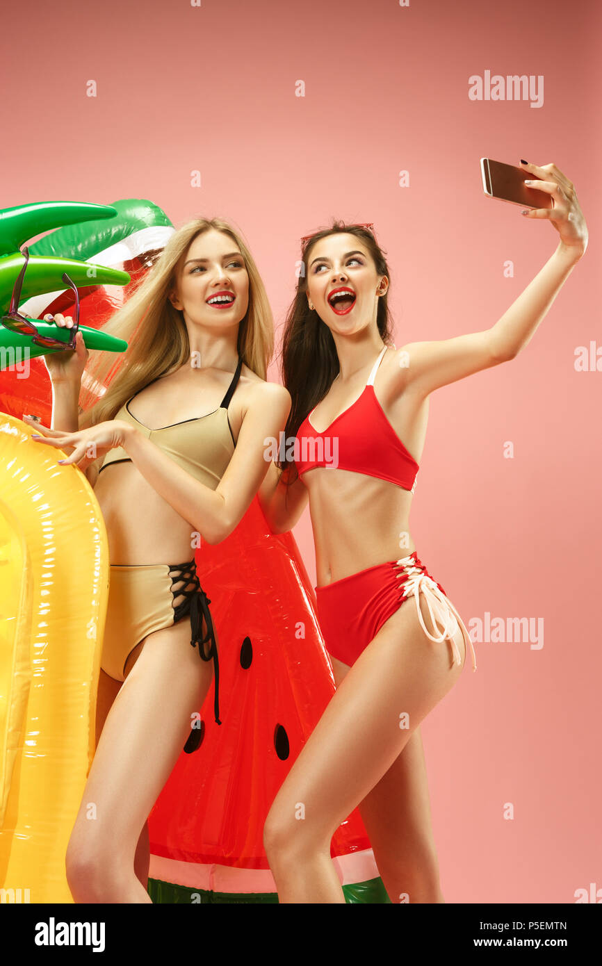 Cute Girls en bañador posando en estudio. Retrato de verano adolescentes  caucásicos sobre fondo de color rosa Fotografía de stock - Alamy