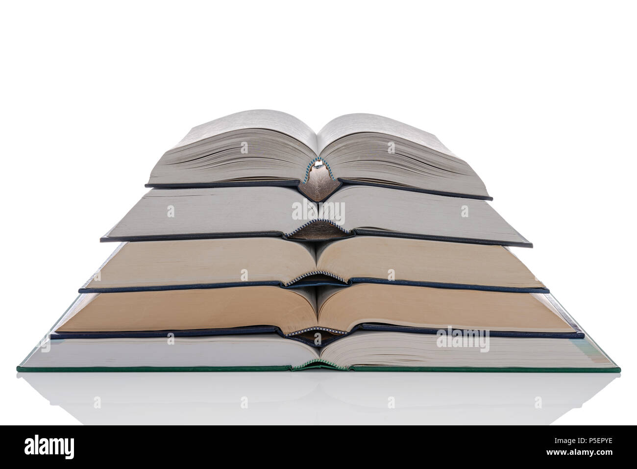 Un montón de cinco libros en tapa dura abierto aislado sobre un fondo blanco. Foto de stock