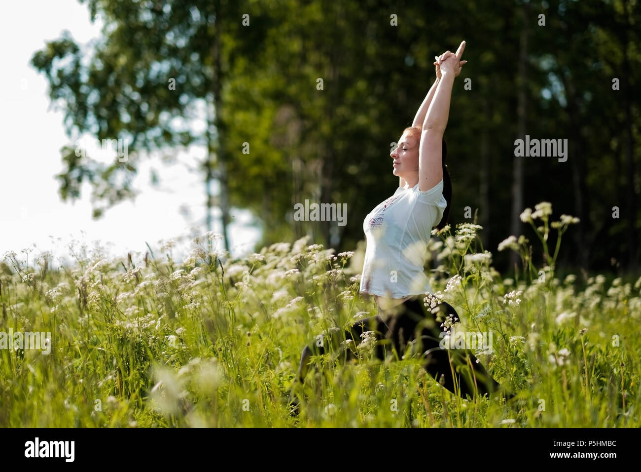 Mujer joven que practica yoga en el parque al aire libre. Foto de stock
