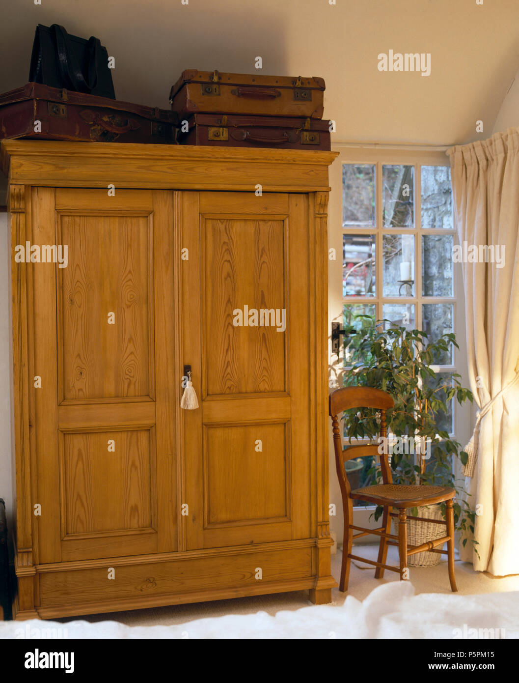 Maletas Vintage en la parte superior de pino antiguo armario ropero en el  dormitorio del país Fotografía de stock - Alamy