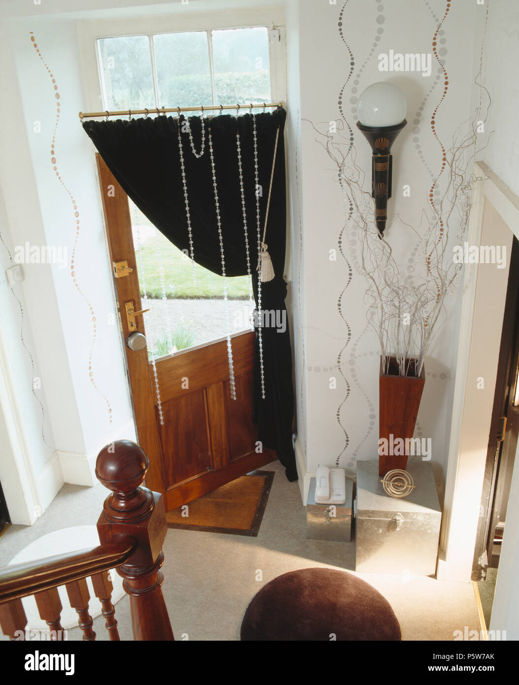 Negro cortina de media puerta acristalada en salón blanco con paredes estampadas Foto de stock