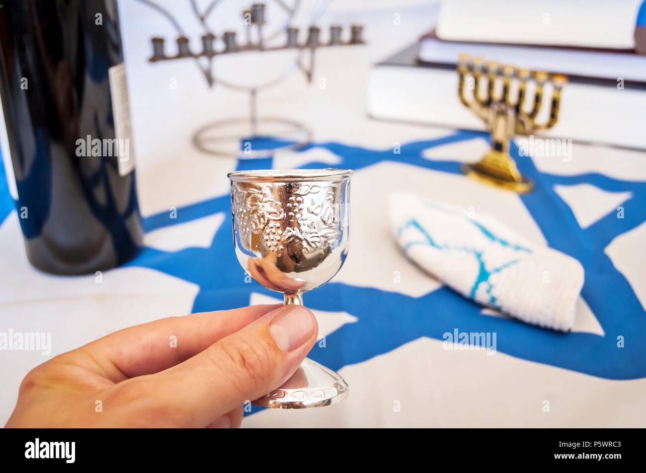 Mano sujetando una "bendición" (vinos kiddush cup, un símbolo religioso