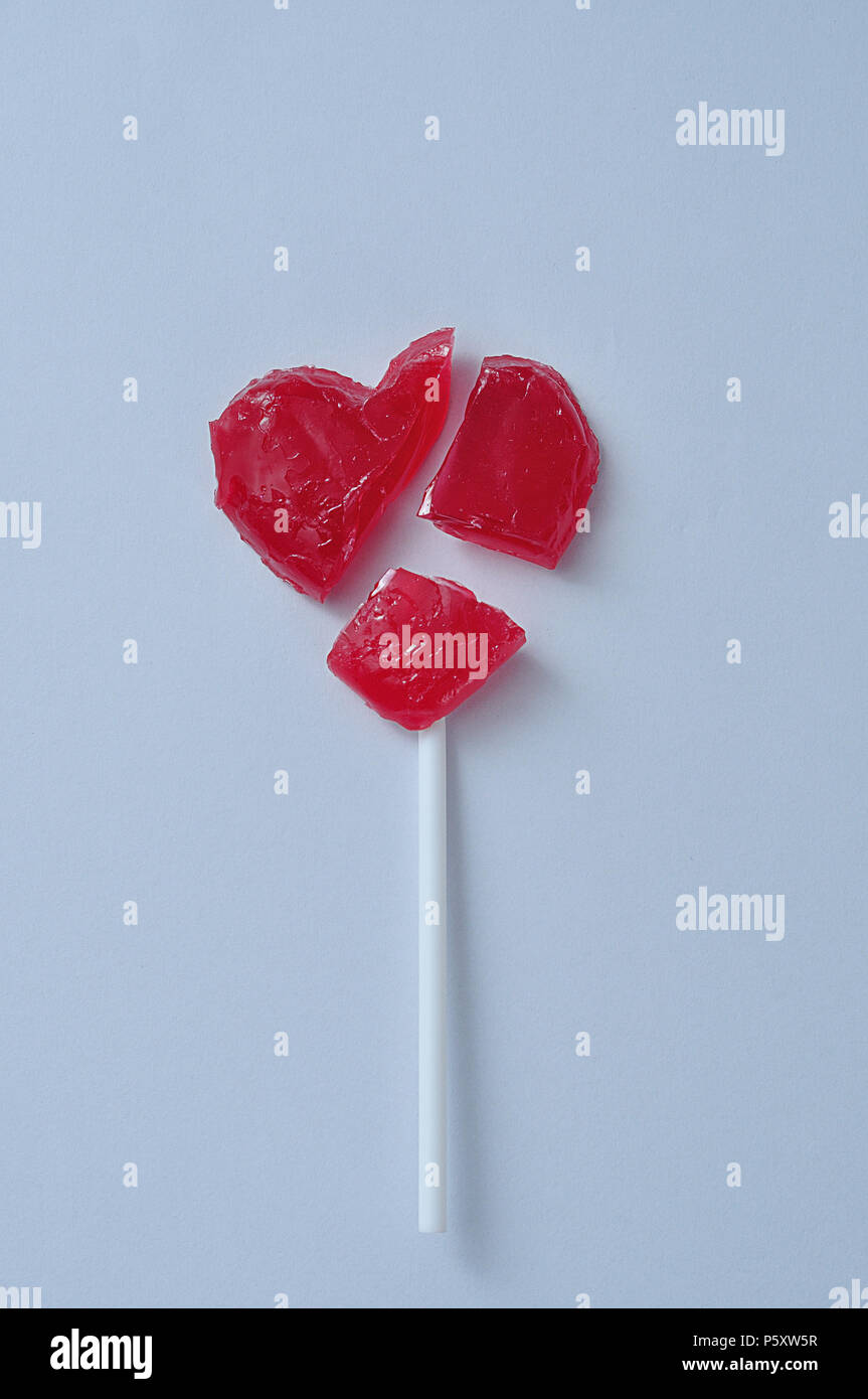 Un corazón rojo roto lollipop simbolizando un corazón roto Foto de stock