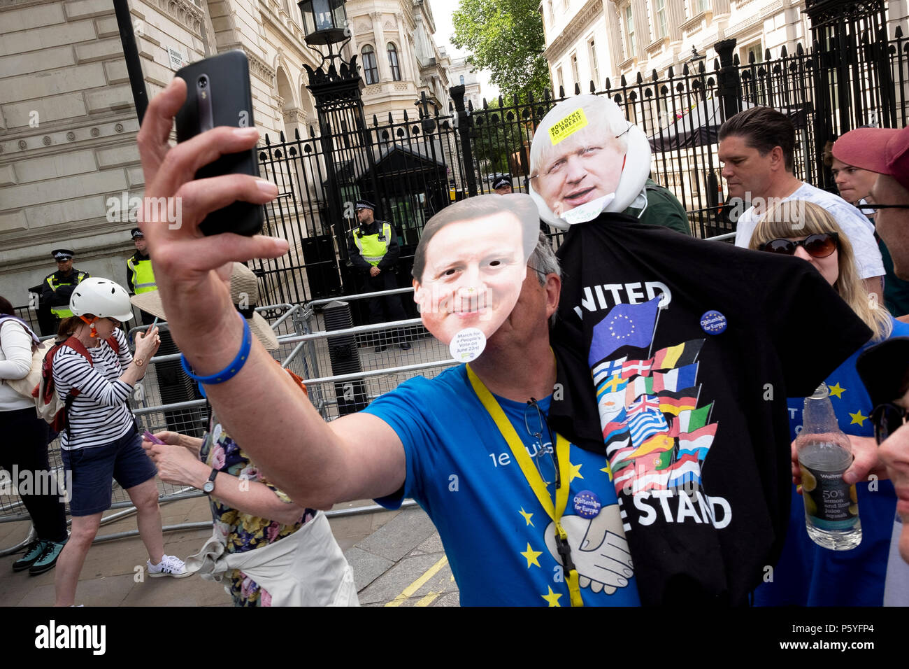 Londres, Reino Unido. El 23 de junio de 2018. Un manifestante llevaba David Cameron y Boris Johnson máscaras toma un selfie fuera el número 10 de Downing Street. Marzo de pueblos Vo Foto de stock