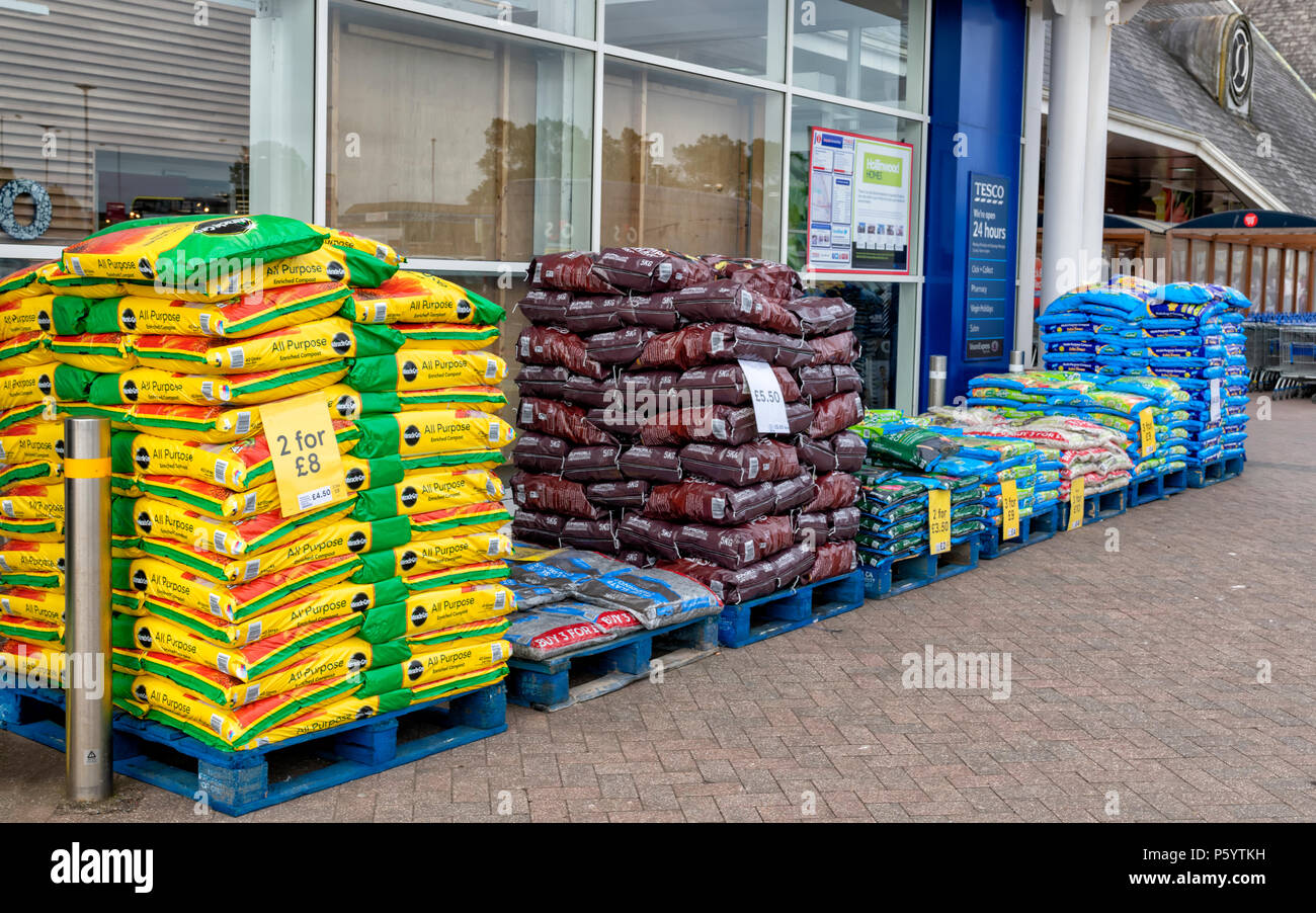 Sacos de abono para semillas apilados fuera de un supermercado Tesco Foto de stock