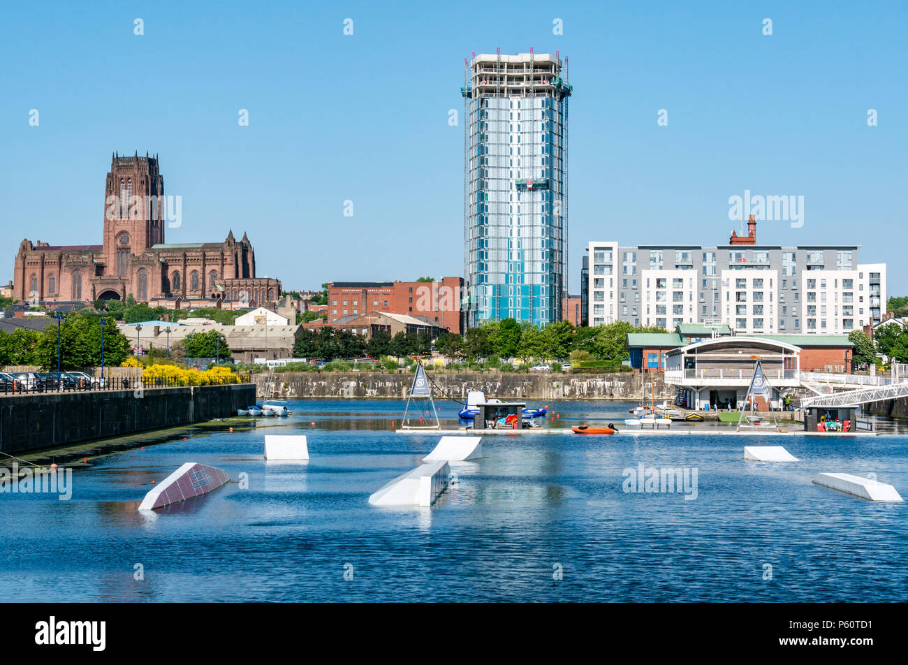 Liverpool, centro de deportes acuáticos, Queen's Dock, con la catedral de Liverpool y moderna torre de apartamentos, Liverpool, Inglaterra, Reino Unido el día soleado con el cielo azul Foto de stock