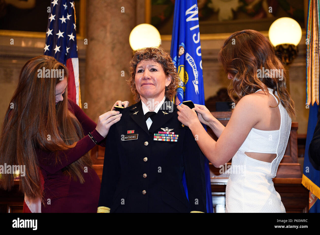 Brig. Gen. Joane Mathews" hijas de Shannon y Lindsey fije su shoulderboards reflejando su nuevo rango durante una ceremonia de promoción formal el 4 de abril en la cámara senatorial del