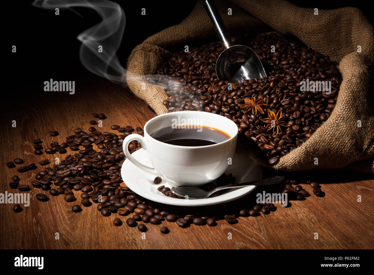 Taza de café, granos de café, bolsa sobre una tabla de madera sobre un  fondo negro Fotografía de stock - Alamy