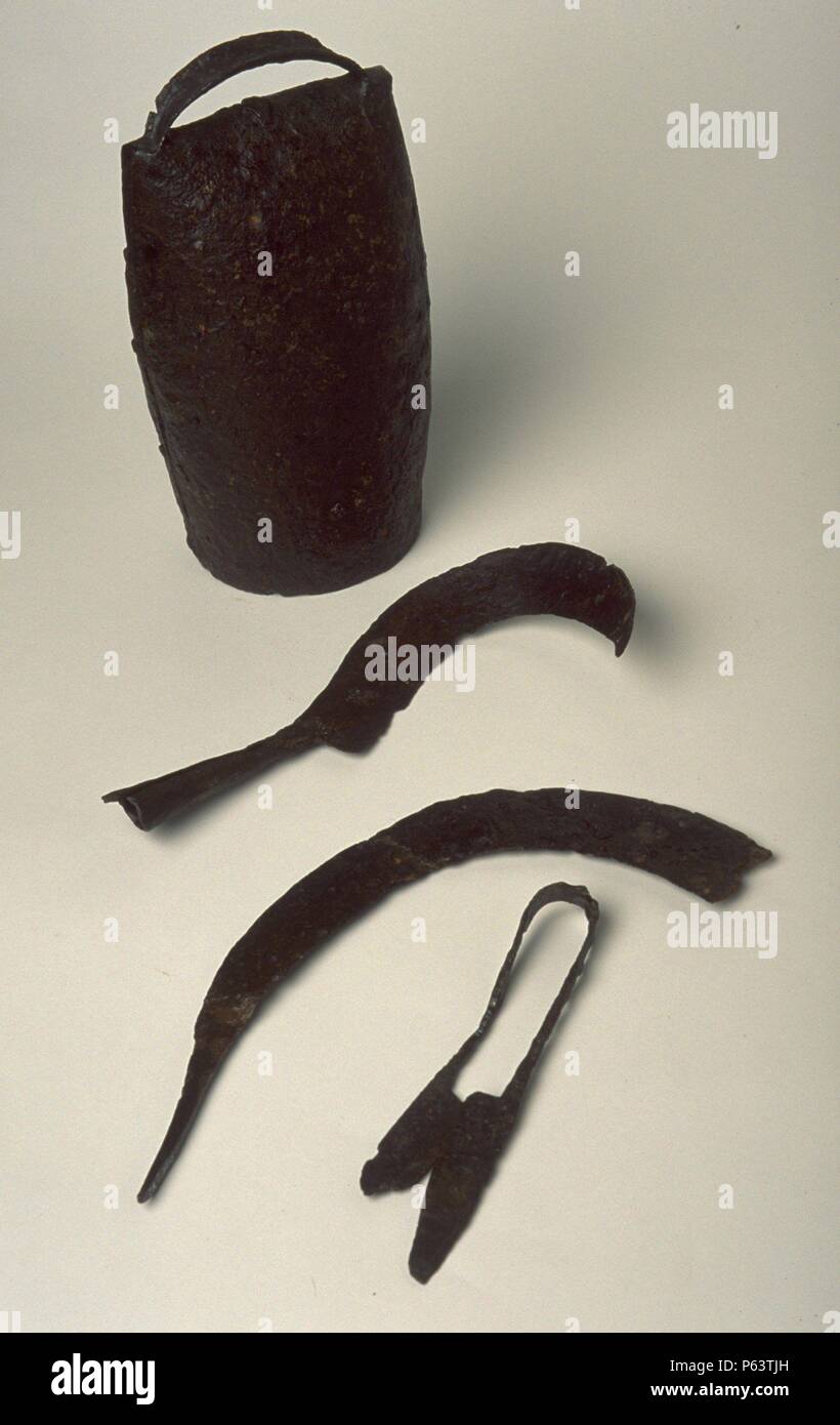 AJUAR FUNERARIO: HERRAMIENTAS DE PASTOREO HOZ PODADERA, cencerro. S.IV VISIGODO.(tu depósito: MUSEO ARQUEOLOGICO NACIONAL). Foto de stock