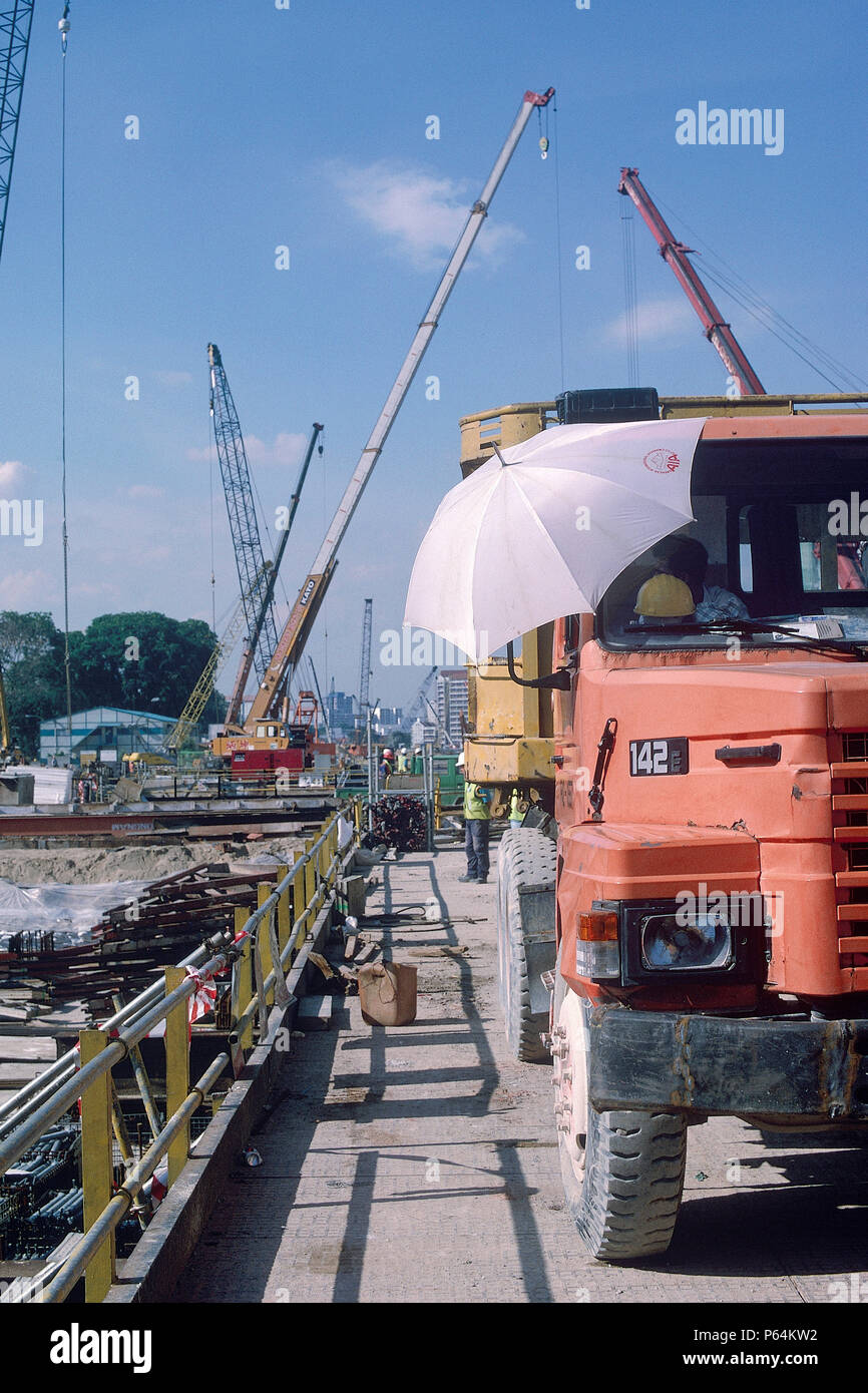 Grúas sobre camión y Singapore Mass Rapid Transit sistema MRT. La construcción de la estación. 2000. Foto de stock