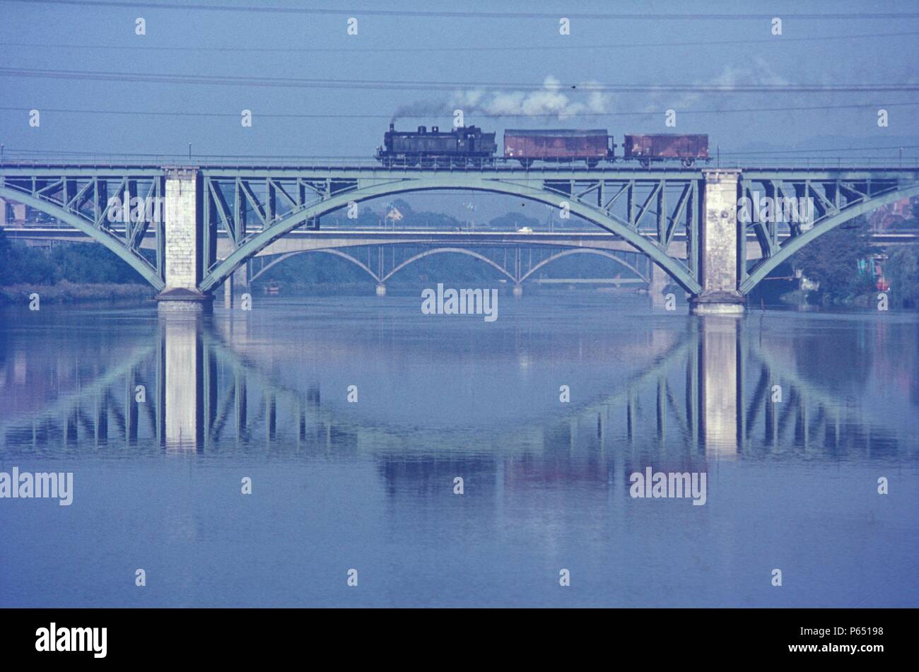 Un viaje local movimiento cruza el viaducto en Maribor con Ferrocarriles Yugoslava 18 Clase 4-6-2T en agosto de 1972. Foto de stock