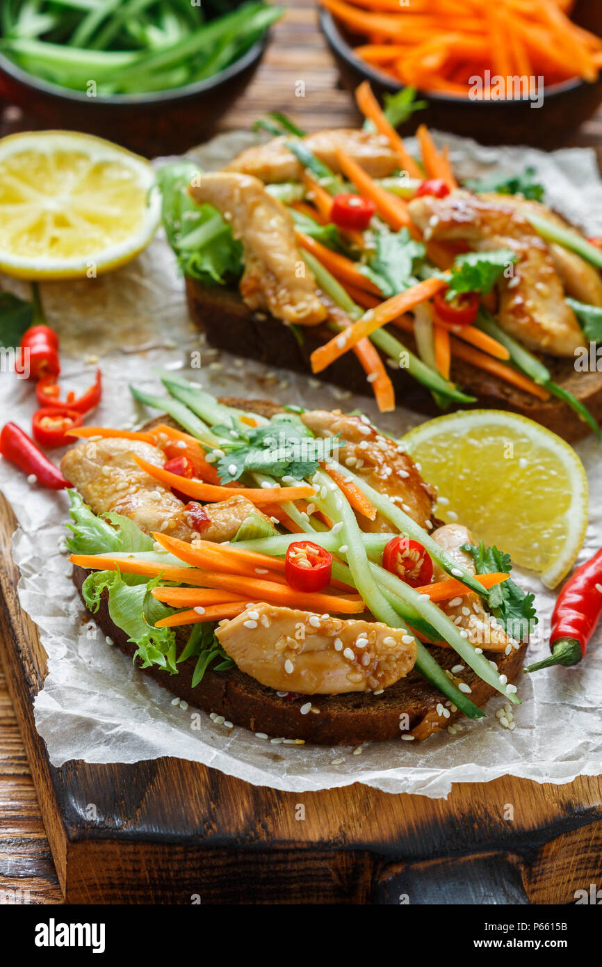 Asian sándwich con pollo frito y verduras frescas de la zanahoria, el