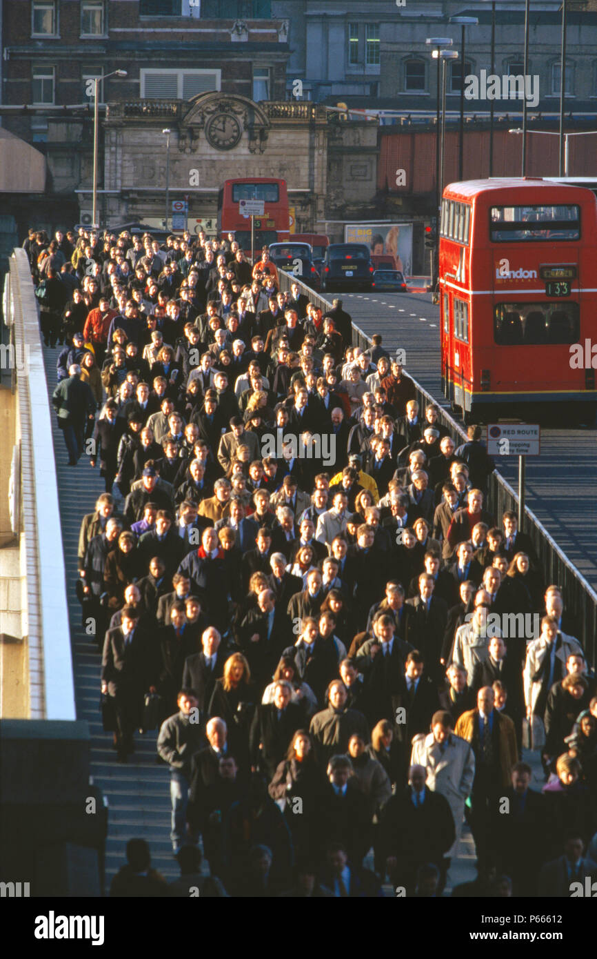 Los viajeros cruzan el Puente de Londres durante la hora punta, Londres, Reino Unido. Foto de stock