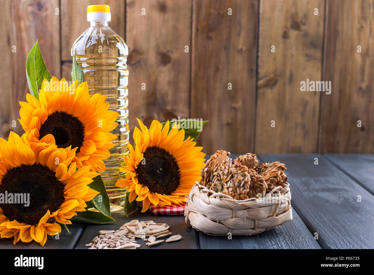 Dodsolnechnoe aceite en una botella grande, un ramo de girasoles flores,  sobre un fondo terned. Hornear casero. Galletas con semillas. Producto  natural, estilo rústico. Espacio de copia Fotografía de stock - Alamy