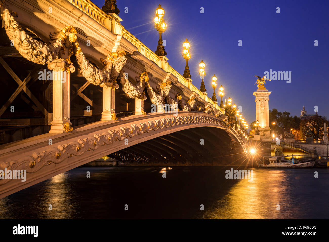 Puente Alexandre III el puente y el río Sena en penumbra. 8º arrondissement, París, Francia Foto de stock