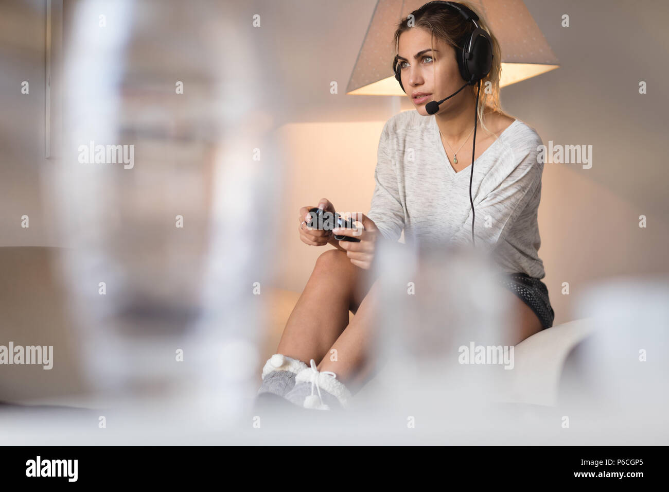 Mujer jugando con auriculares de videojuegos en el salón Foto de stock