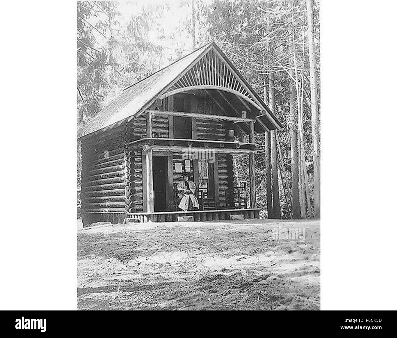 Inglés: Mujer sentada en el porche de la cabaña, lugar no identificado, 14  de agosto de 1908 . Inglés: Título del álbum: 8-14-08 PH Coll   sujetos (LCTGM): cabañas de madera--Washington (