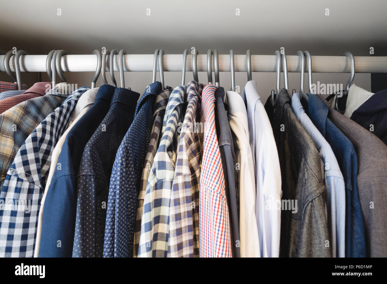 Varios camisas colgadas en perchas en casa Fotografía de stock - Alamy