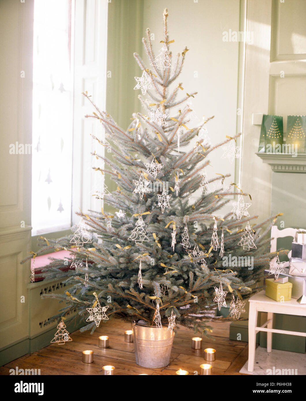 Anillo de velas alrededor de un árbol de navidad decorado con escarcha  artificial y con estrellas de vidrio en la esquina del comedor Fotografía  de stock - Alamy