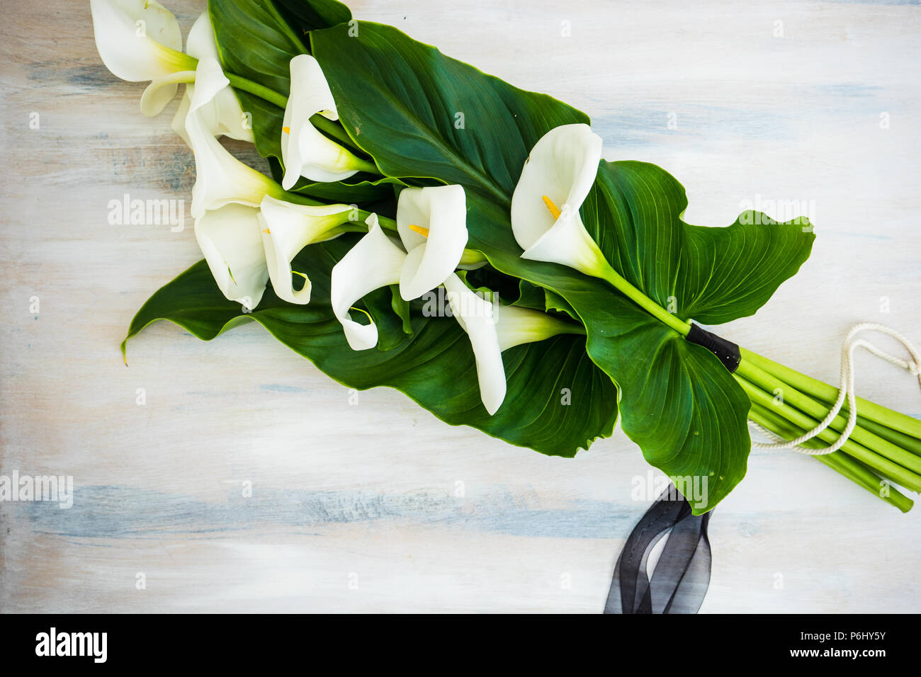Hermosas calas blancas en un ramo sobre fondo rústico Fotografía de stock -  Alamy