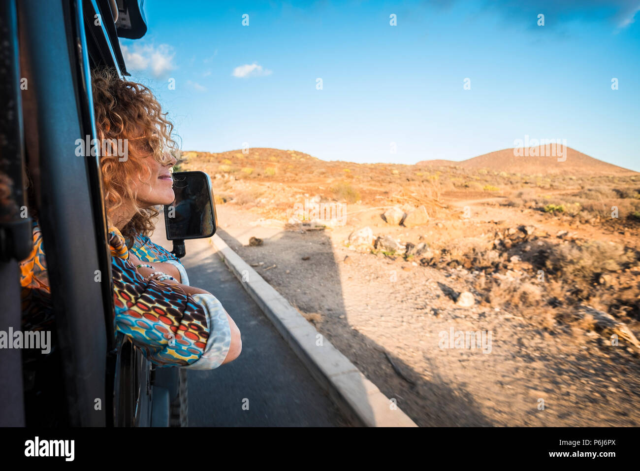 Hermosa joven mujer caucásica viajando con un coche negro off road y mirando el paisaje exterior. el desierto y las montañas viaje pintoresco lugar para n Foto de stock