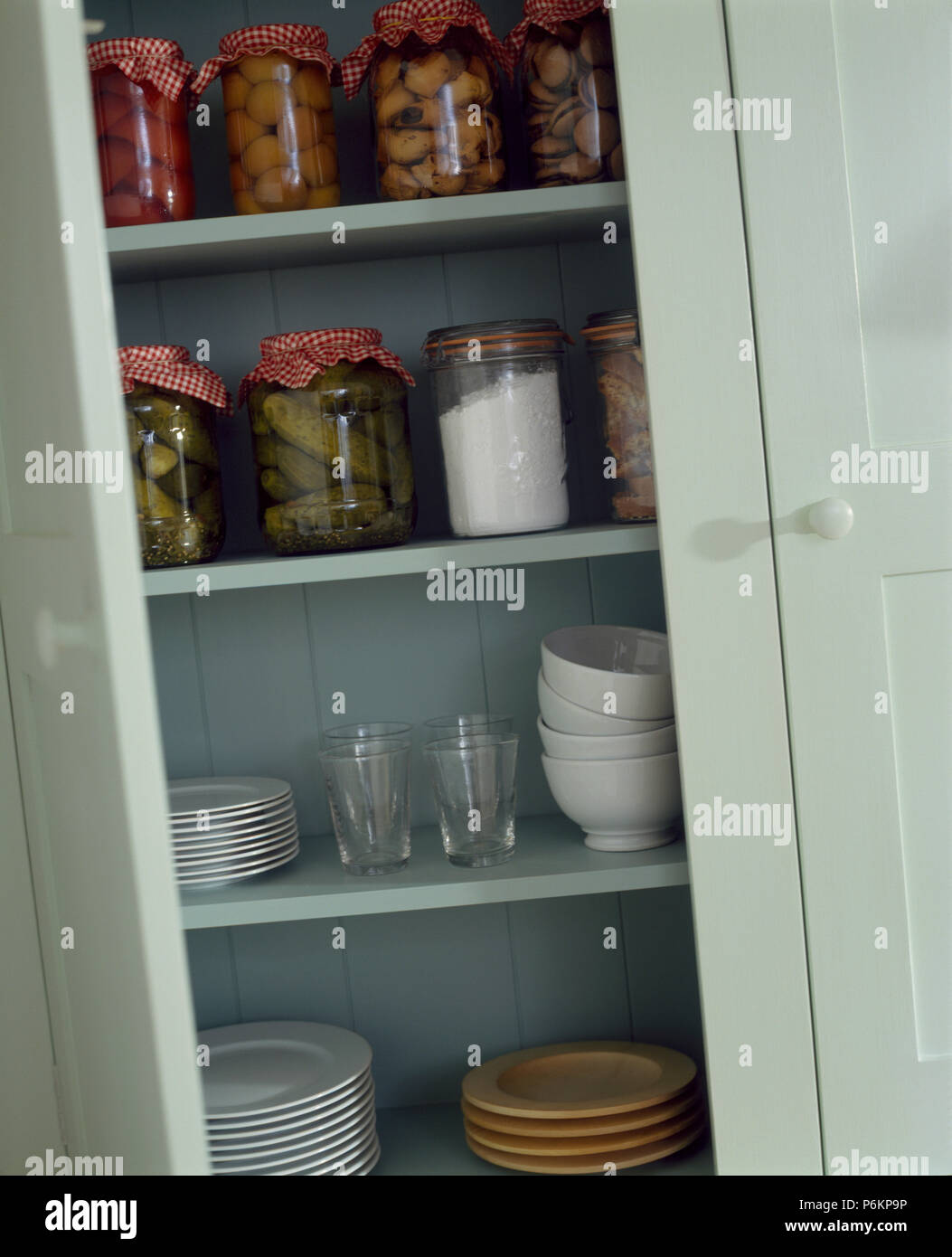 Close-up de tarros de pickles caseros en estantes con tazones y platos en  el armario azul pálido Fotografía de stock - Alamy