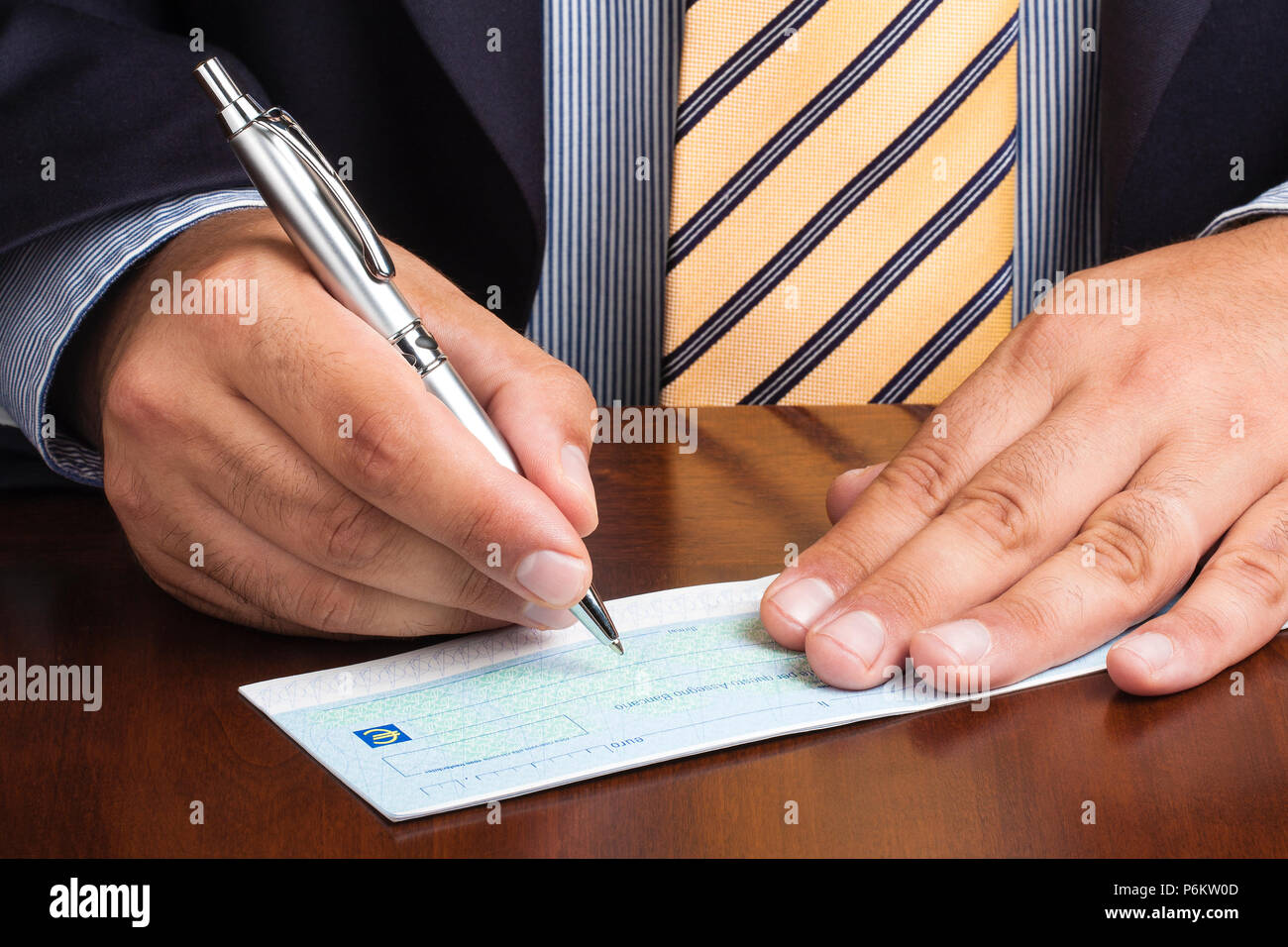 Acercamiento del empresario o vendedor firma de escritura a mano cheque en blanco Foto de stock