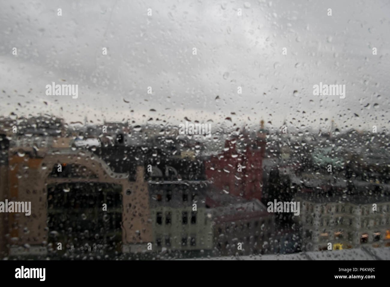 gotas-de-agua-en-la-ventana-la-abstraccion-gotas-de-lluvia-en-una-ventana-con-vista-a-la-ciudad-en-el-fondo-p6kwjc.jpg