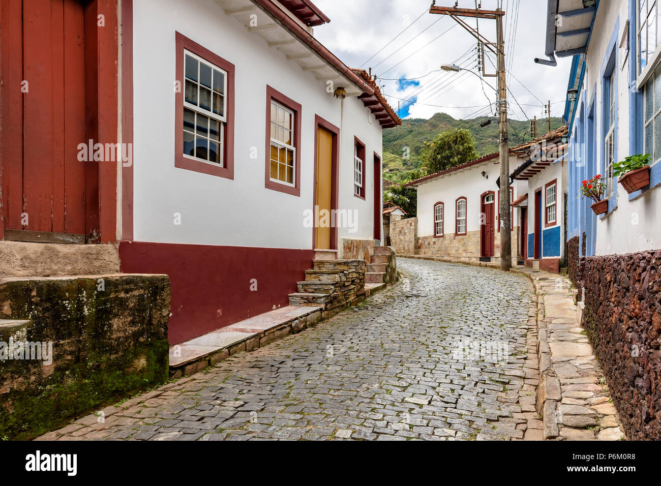 Antigua calle de adoquines, con casas de arquitectura colonial en la ciudad de Ouro Preto en Minas Gerais Foto de stock