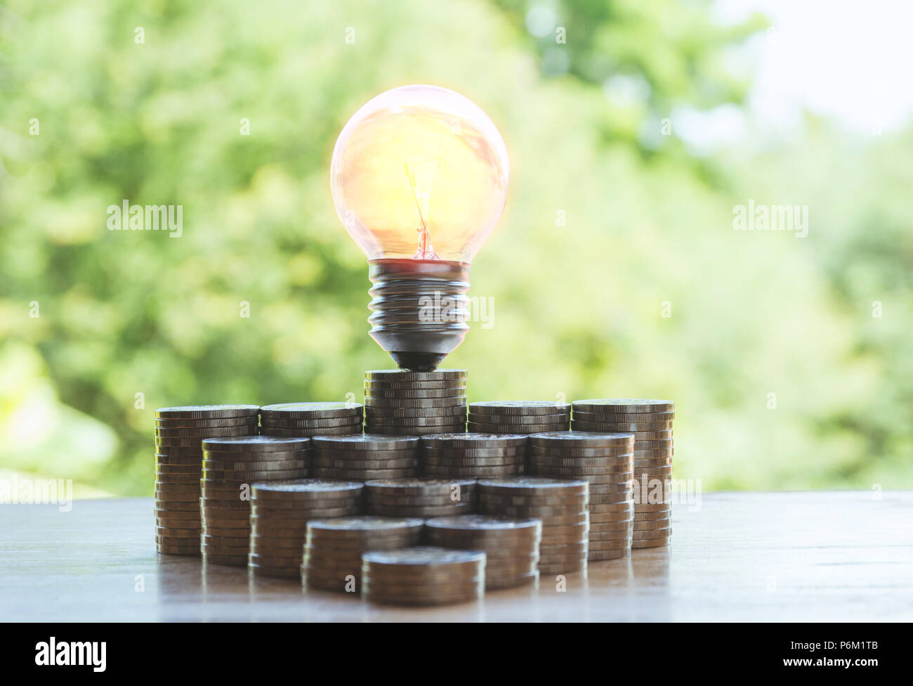 Bombilla de ahorro de energía y el árbol creciendo en pilas de monedas en  el fondo de la naturaleza Fotografía de stock - Alamy