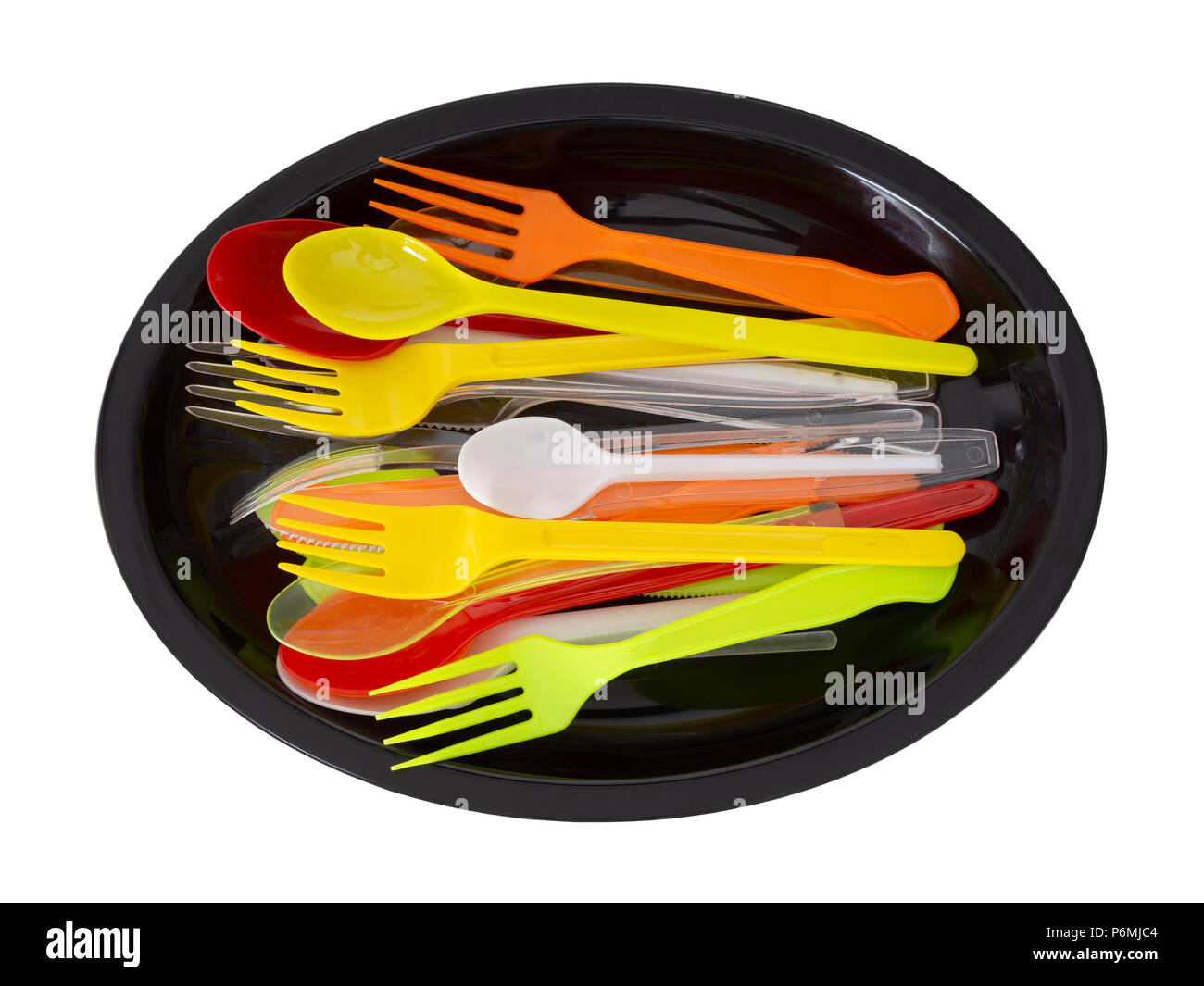 Cuchillos de plástico, tenedores y cucharas sobre placa negra aislado en blanco. Foto de stock