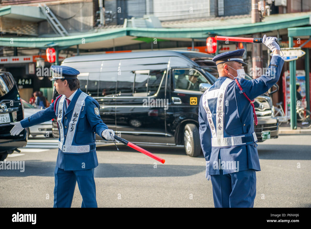 La policía de tráfico japonés en acción en una concurrida calle en el distrito Gion de Kyoto. Foto de stock