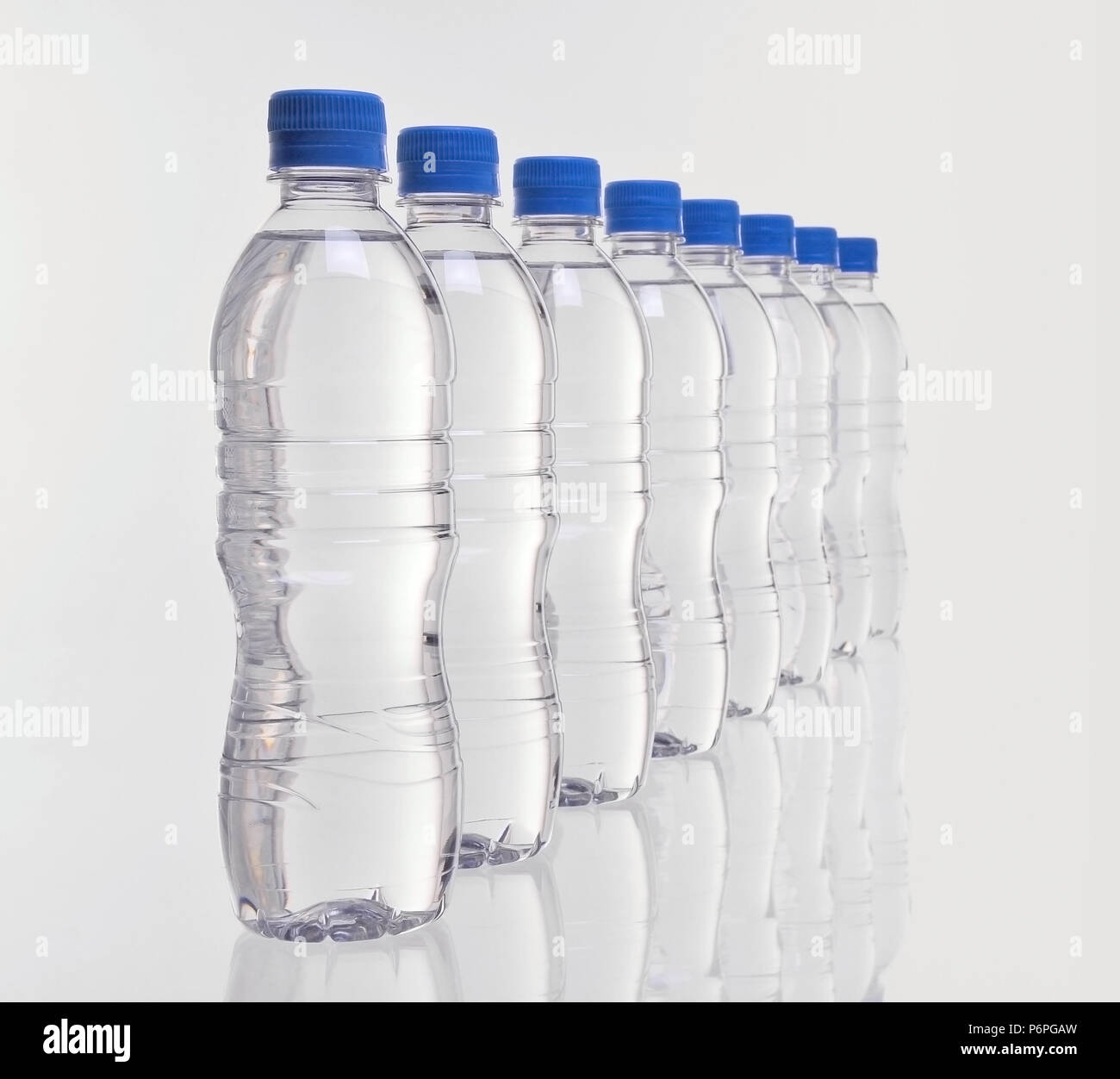 Fila de ocho botellas de plástico para agua desaparece en la distancia con  el foco en la parte delantera de botellas Fotografía de stock - Alamy