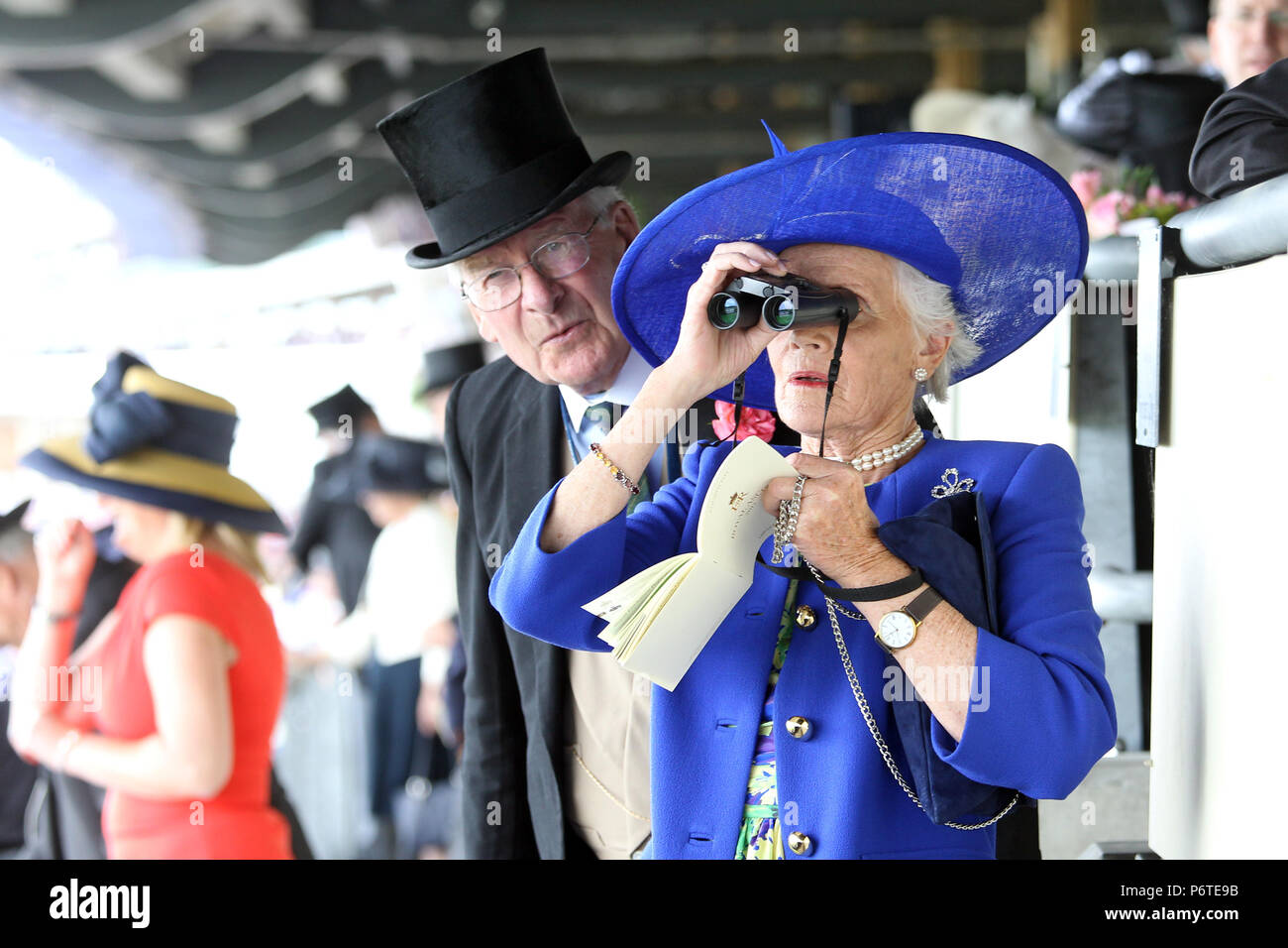 Royal Ascot, la moda, la mujer tiene una mirada a través de sus binoculares Foto de stock