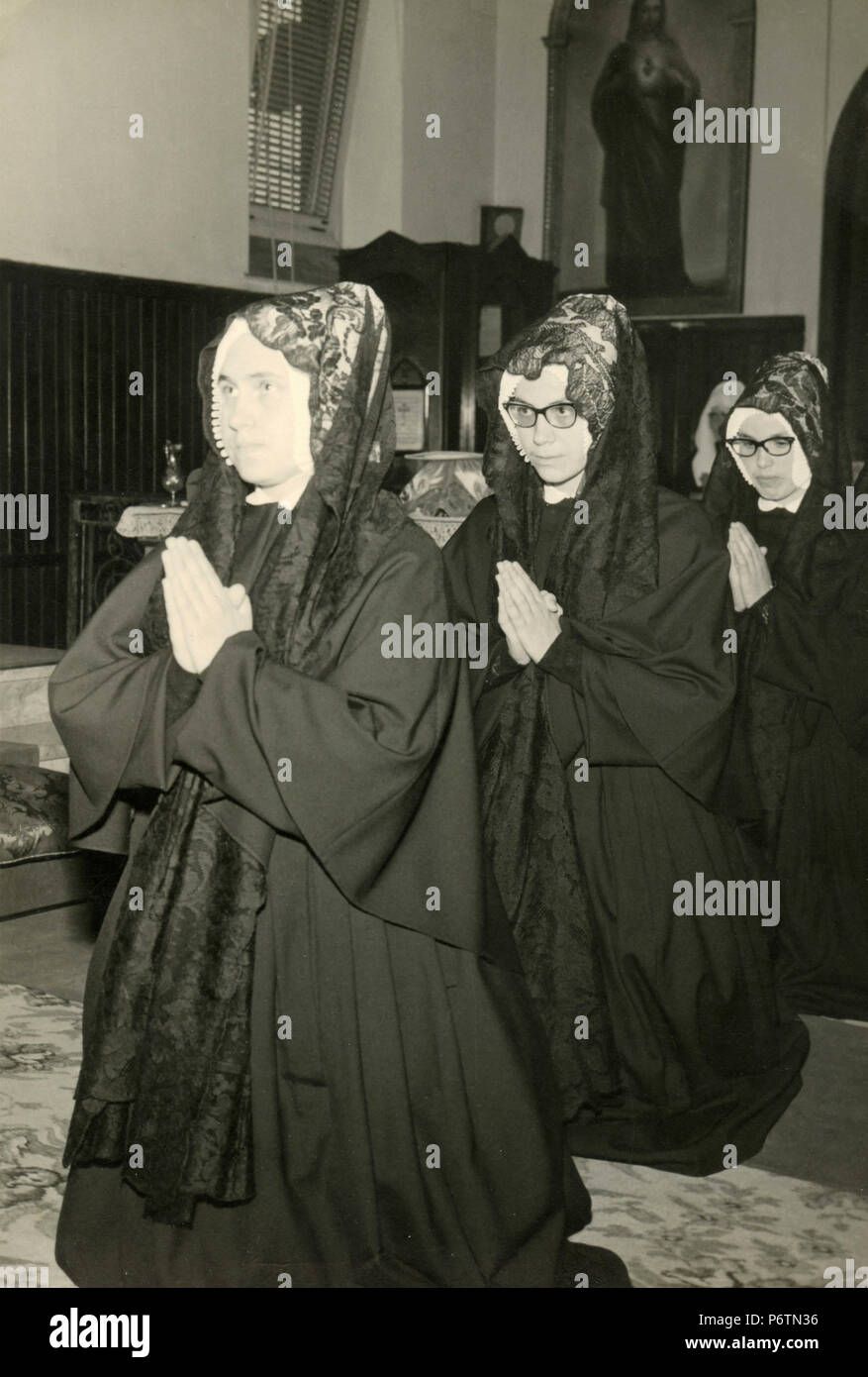 Tres mujeres vestidas de negro durante una ceremonia religiosa católica,  Italia 1964 Fotografía de stock - Alamy