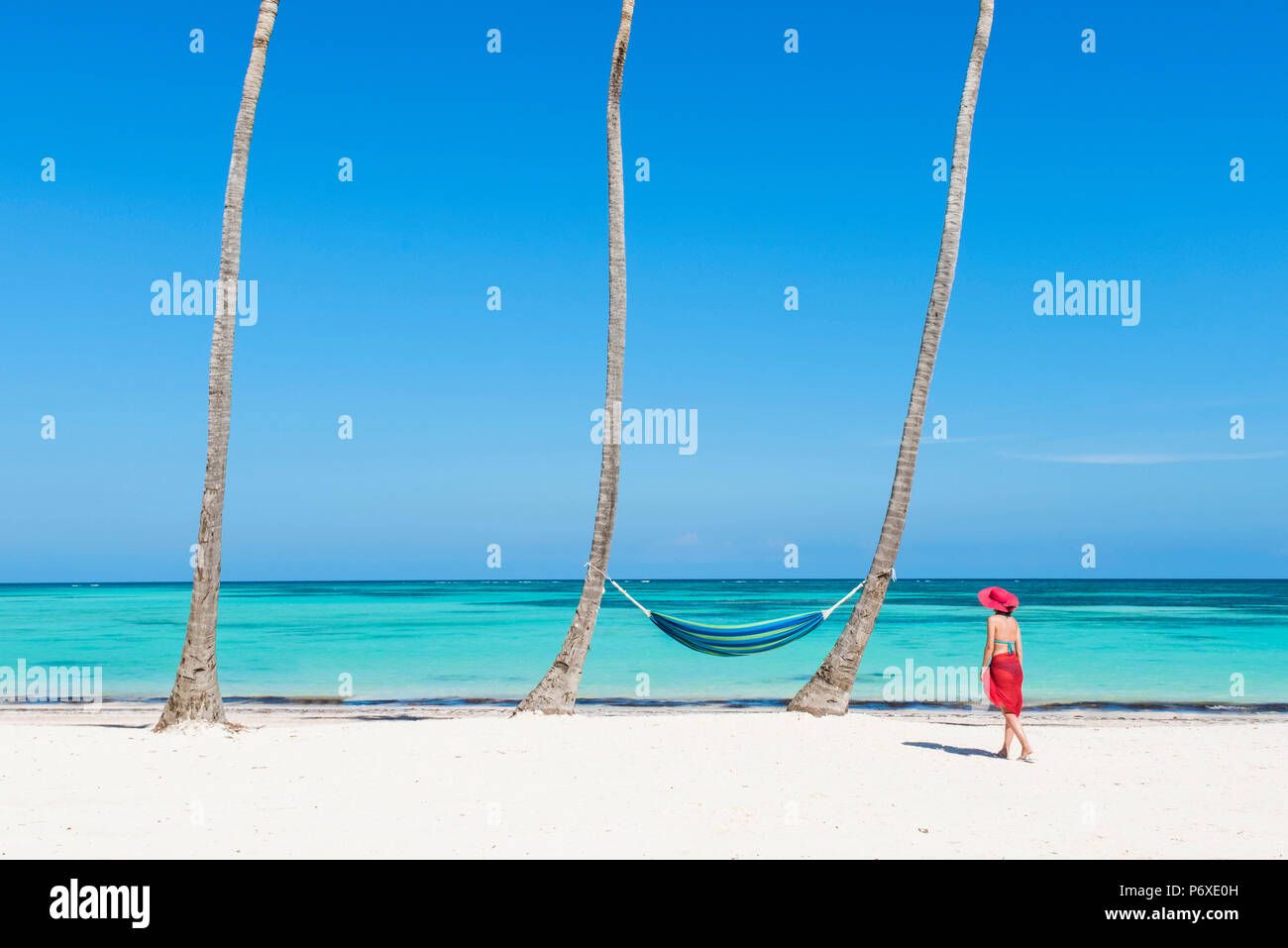 Juanillo Beach (Playa Juanillo, Punta Cana, República Dominicana. Mujer caminando en una playa llena de palmeras (MR). Foto de stock