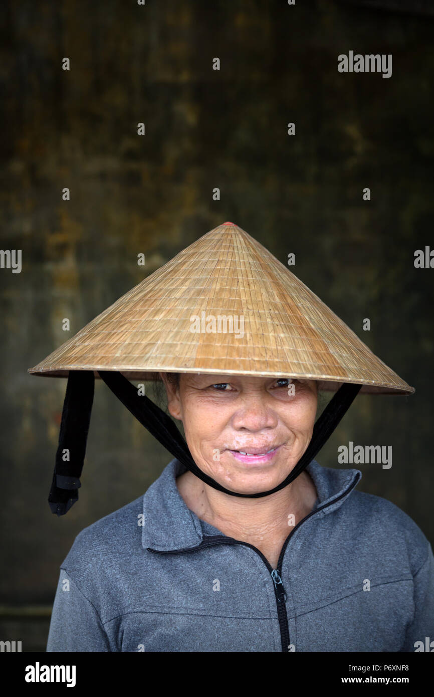 Retrato de mujer con sombrero cónico tradicional , Hoi An , Vietnam Foto de stock