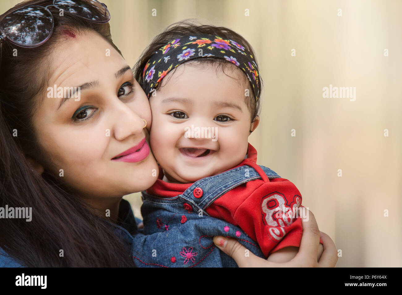 Madre e hija abrazos y sonriendo a la cámara en el parque. El enfoque selectivo, poca profundidad de campo. Foto de stock