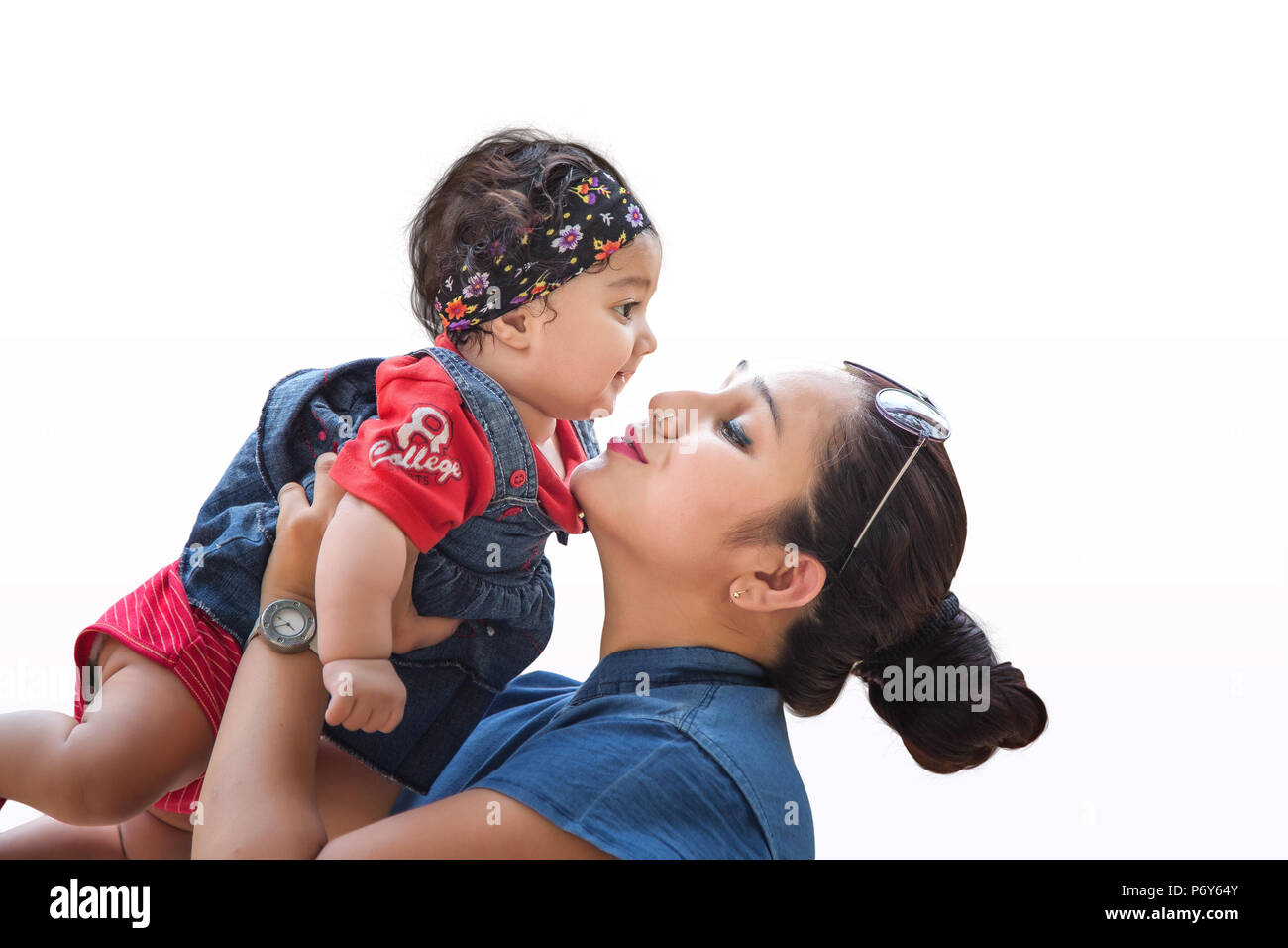 Madre sosteniendo su hermosa hija aislado sobre fondo blanco. Foto de stock