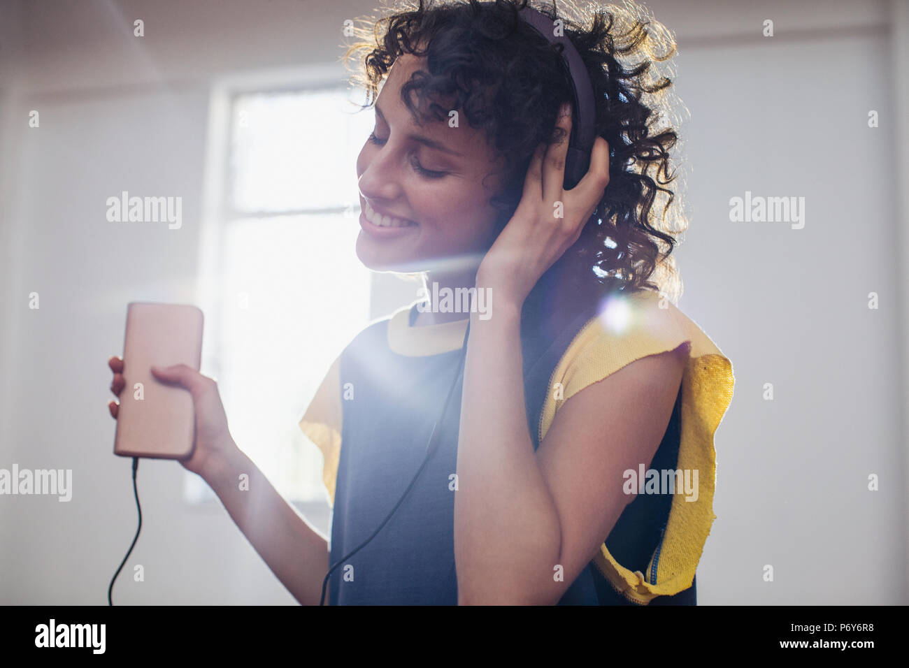 Sonriente joven despreocupado, escuchar música con auriculares y reproductor de mp3 Foto de stock