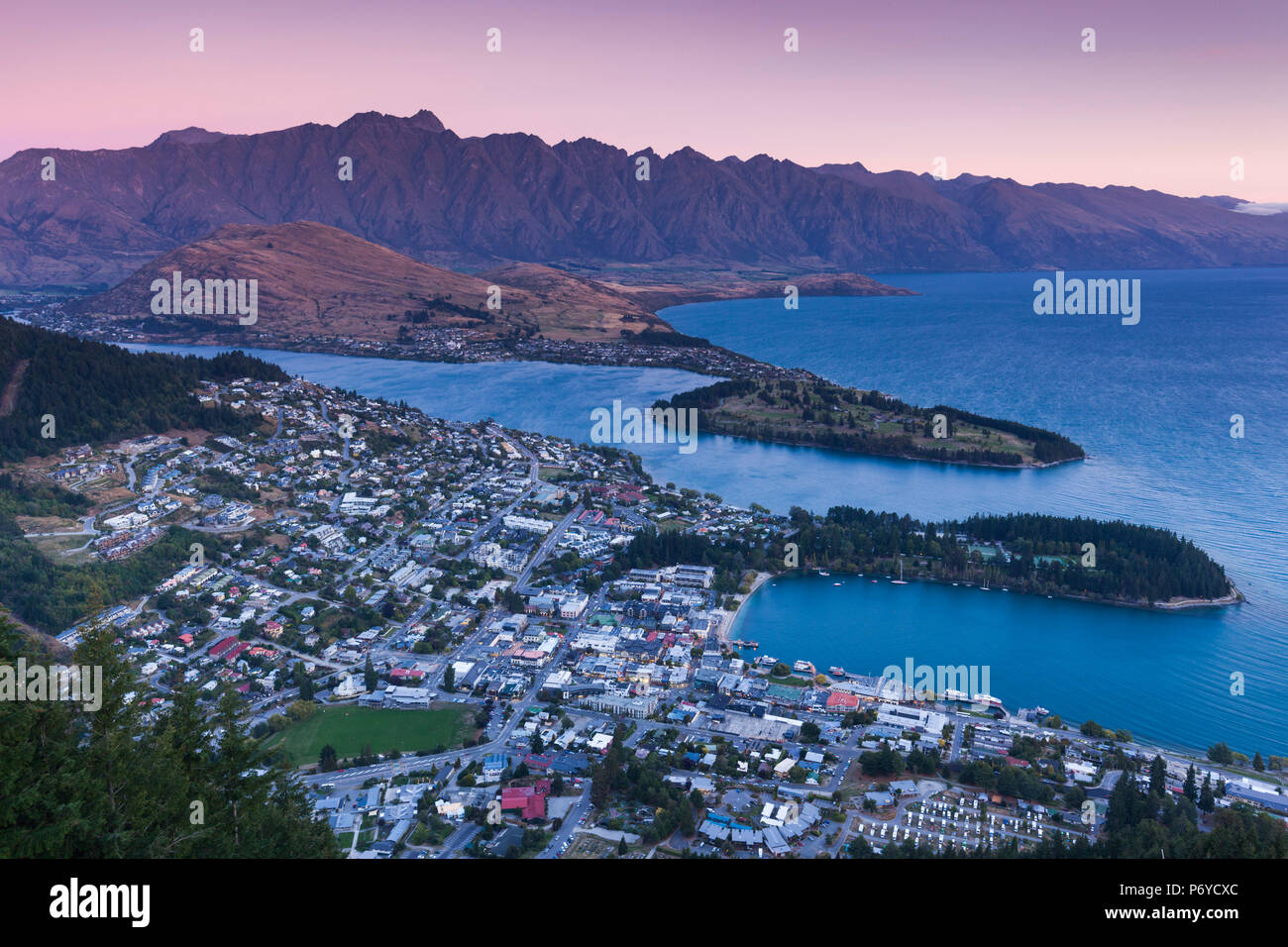 Nueva Zelanda, Otago, Isla del Sur, Queenstown, ciudad elevada vista con los Remarkables desde el Teleférico Skyline deck, el anochecer Foto de stock