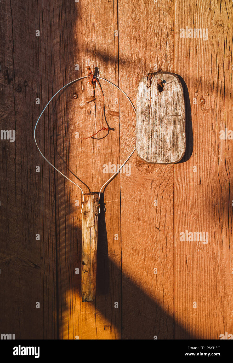 Herramientas de pesca artesanal antiguo colgado en la pared de madera de  color naranja en la luz del sol Fotografía de stock - Alamy