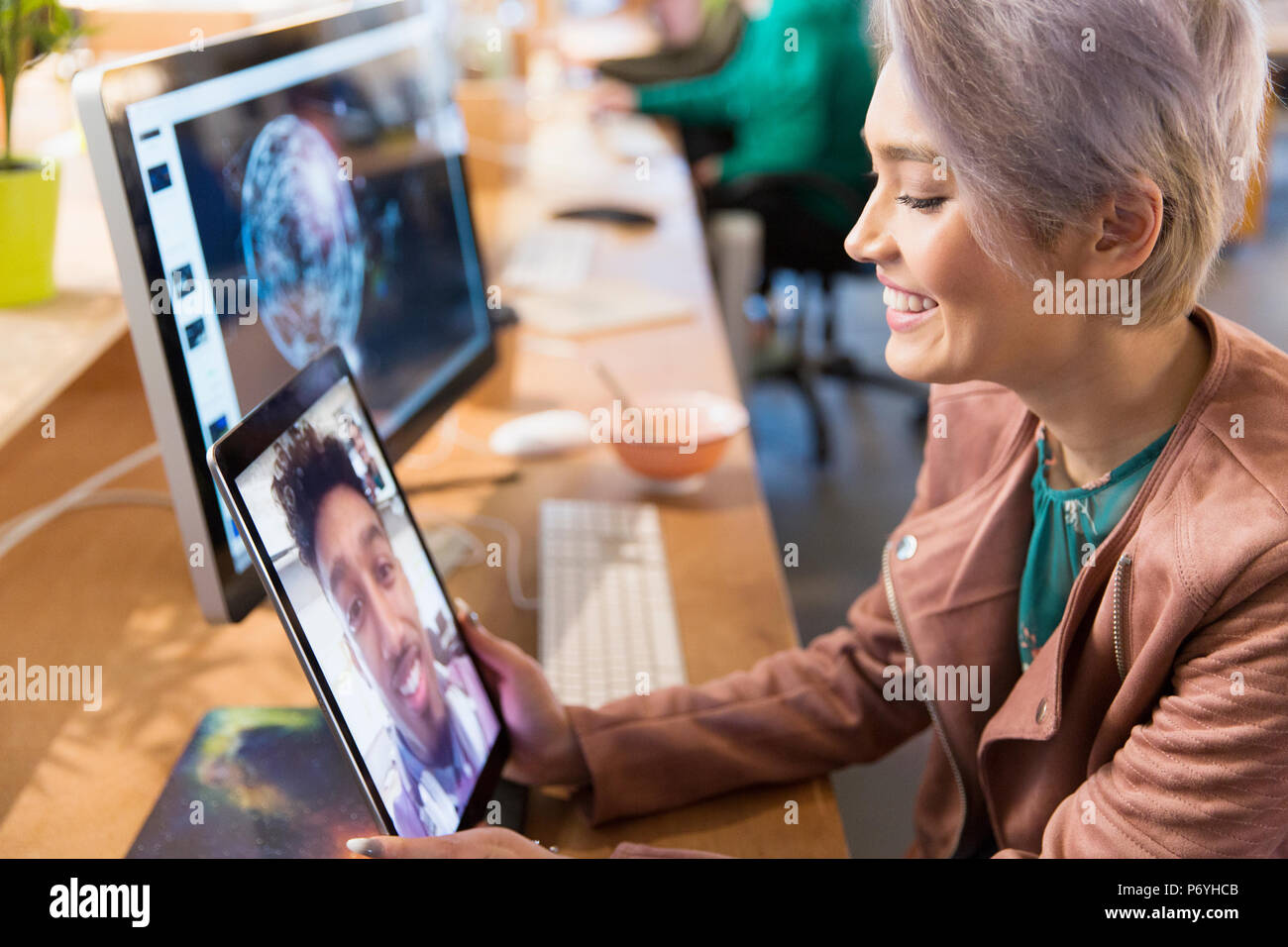 La empresaria creativa videochats con su colega sobre la tableta digital en Office Foto de stock