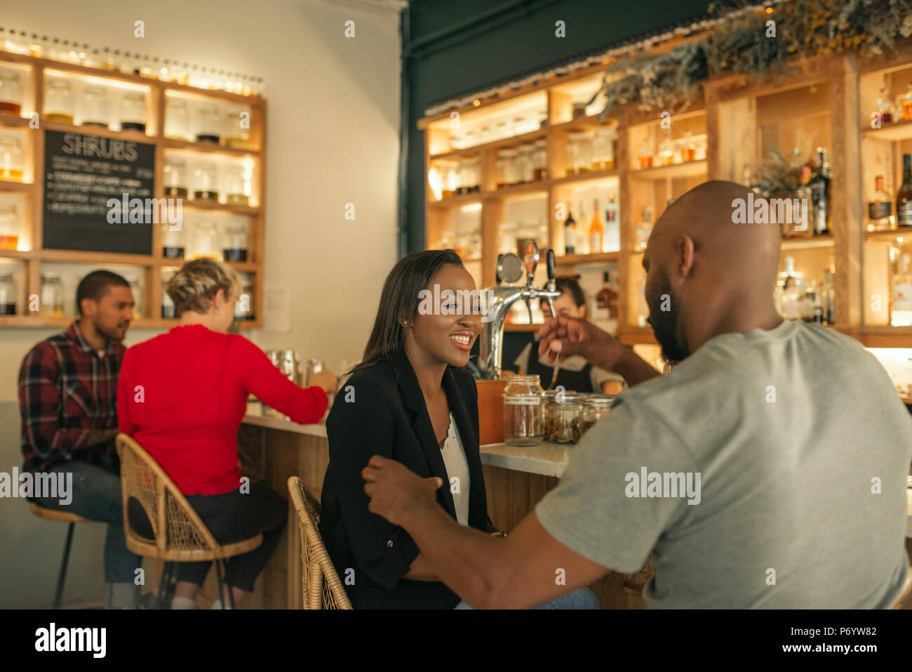 Sonriente pareja americana africana juntos y disfrutar de una copa en un bar. Foto de stock