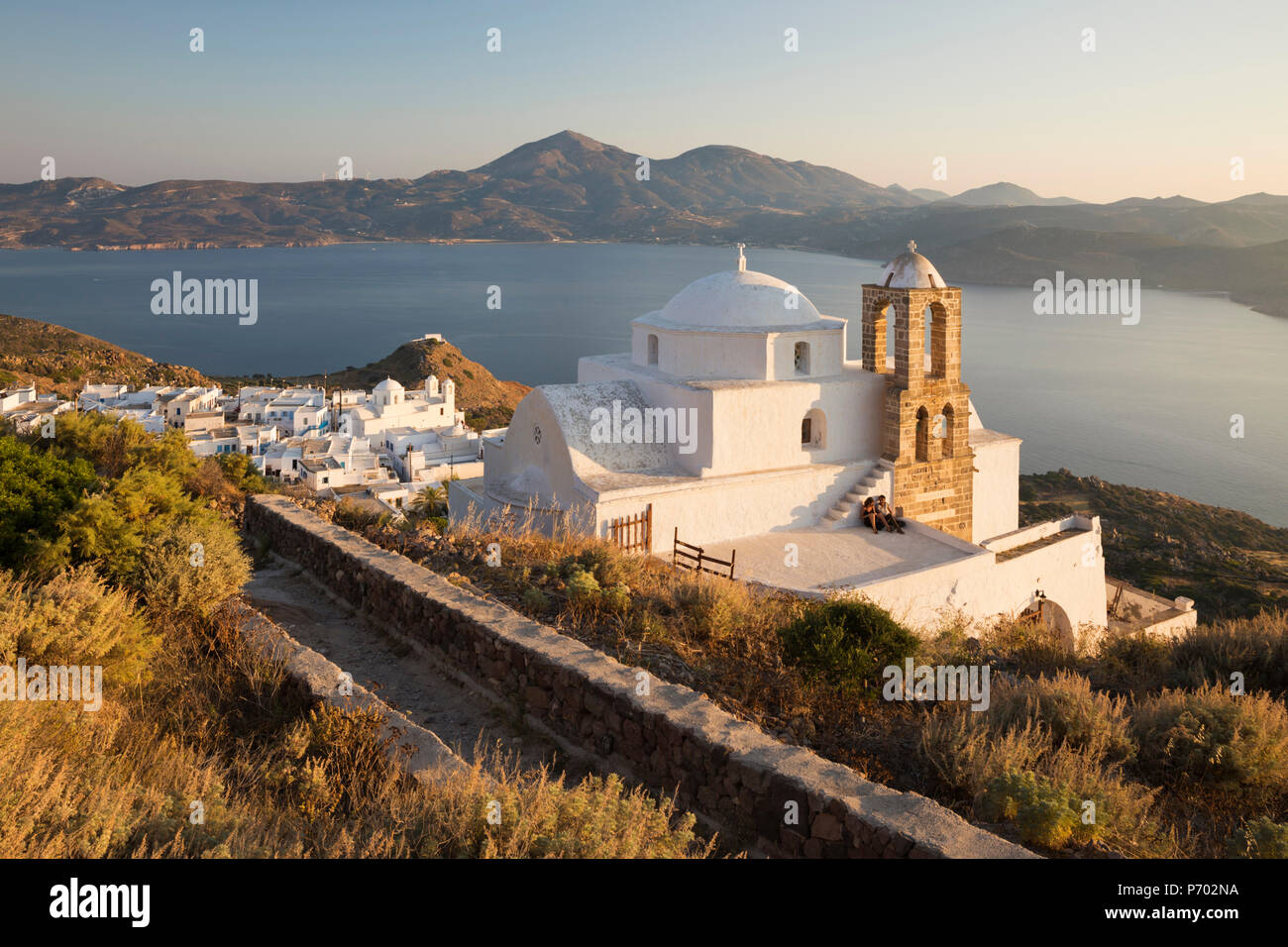 Vista de Plaka, con iglesia ortodoxa griega y Milos Bahía del castillo de Plaka, Milos, Cyclades, islas griegas del Mar Egeo, Grecia, Europa Foto de stock