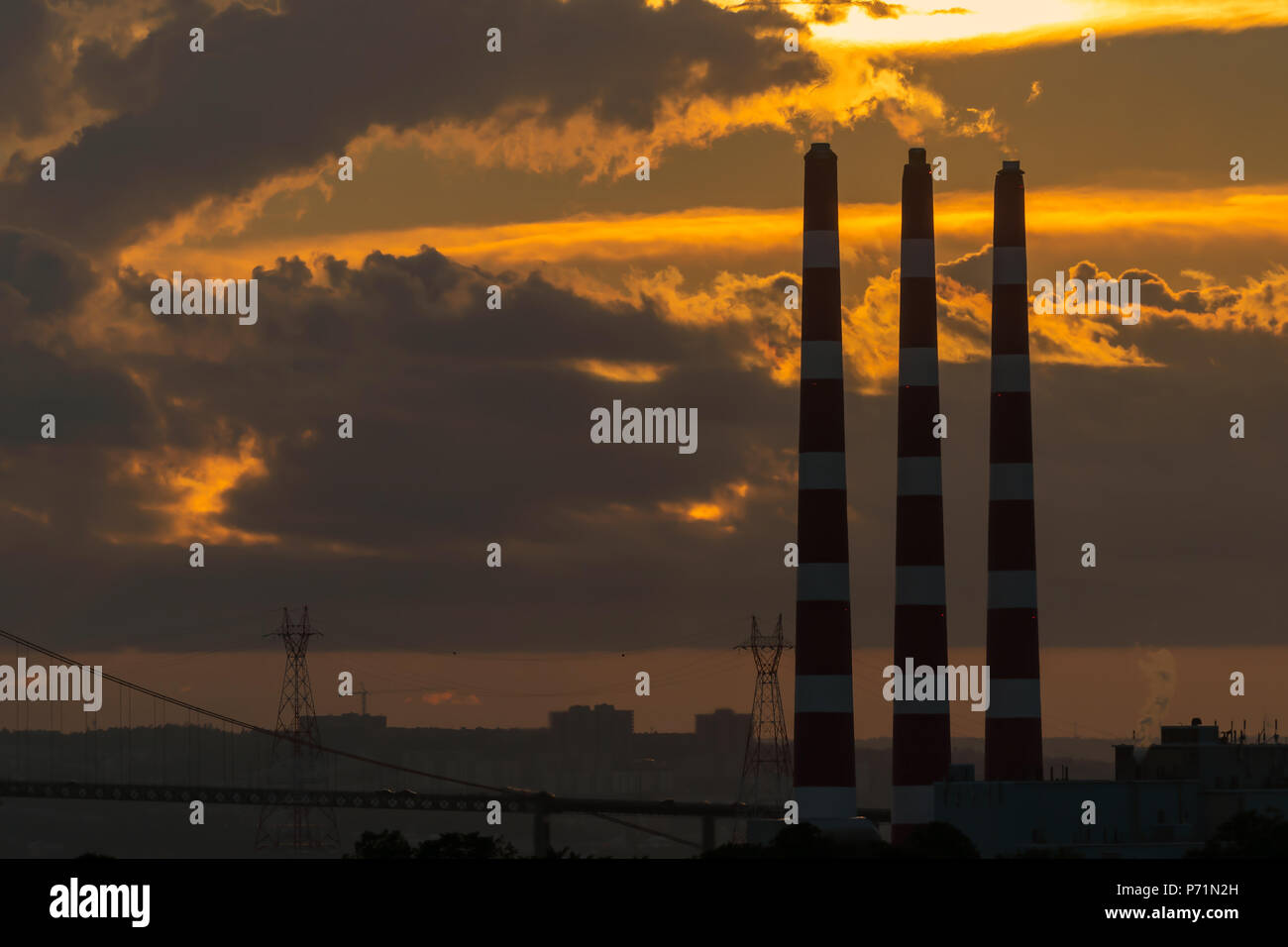 Columnas de humo de una planta de energía de carbón al anochecer. Foto de stock
